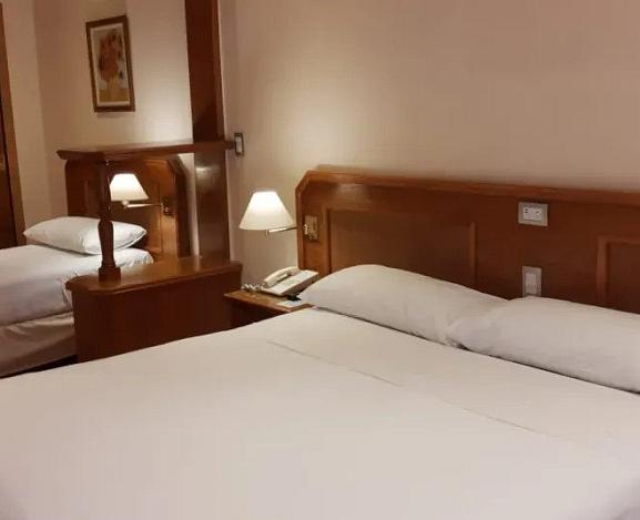 Quarto triplo com cama de casal e cama de solteiro com vista lateral